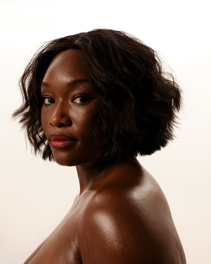 Woman with short, wavy hair against a plain background